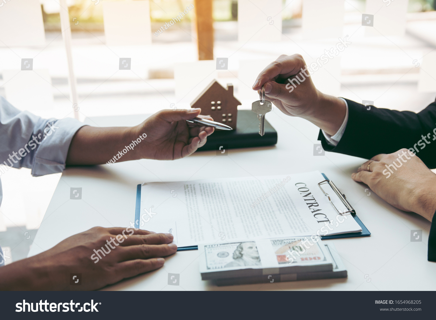 Stock photo insurance brokers are pointing to insurance contract signing and are explaining to customers at the 1654968205