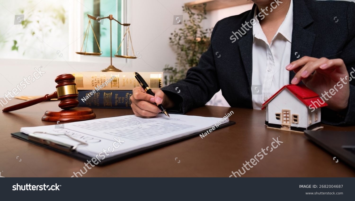Stock photo legal documentation lawyer signing property contract with gavel and model house 2682004687
