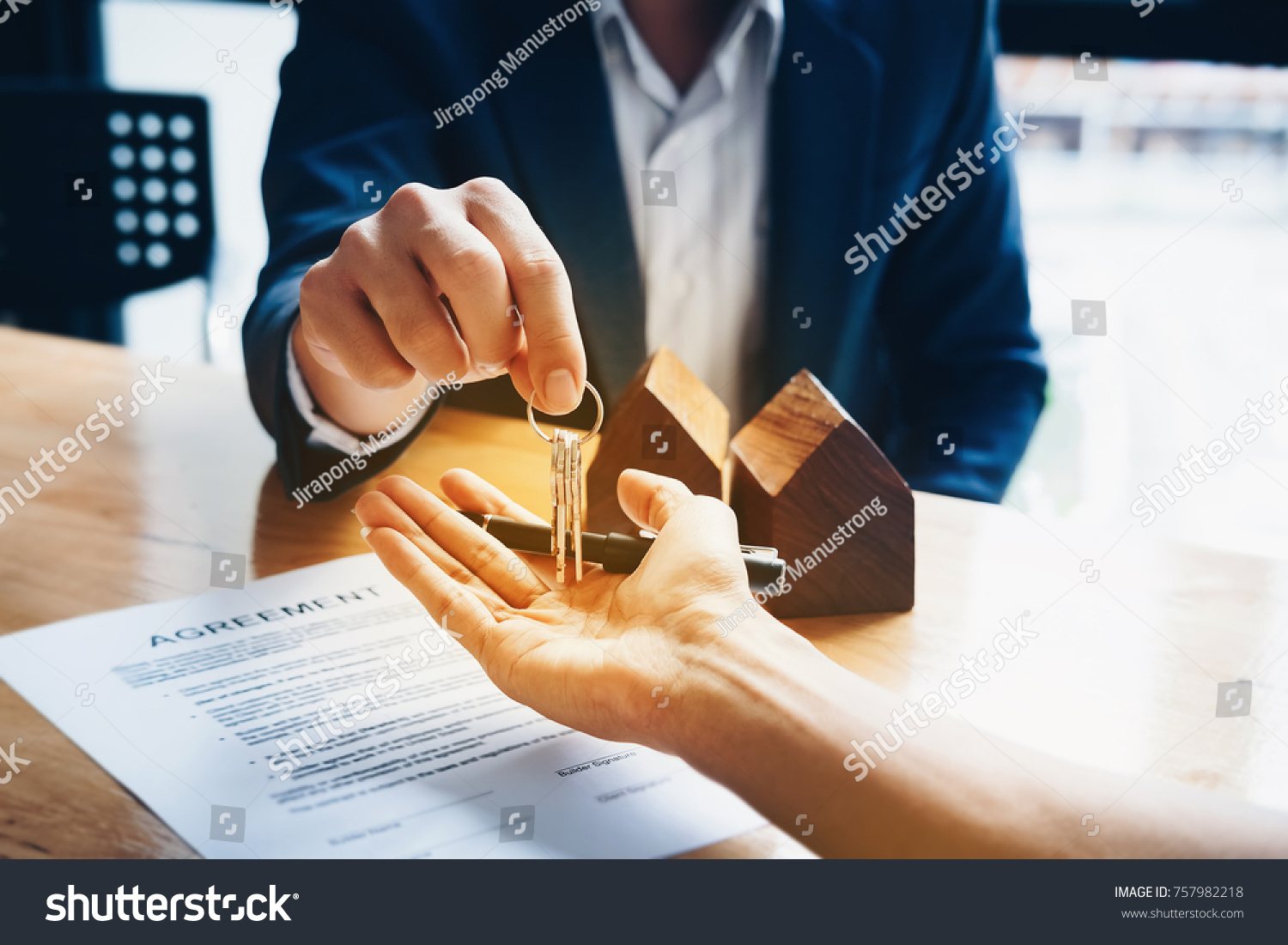 Stock photo real estate agents agree to buy a home and give keys to clients at their agency s offices concept 757982218